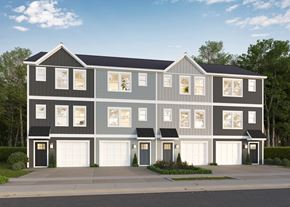Charlotte townhouse for rent - A modern two-story house with a grey and white exterior and black garage doors.