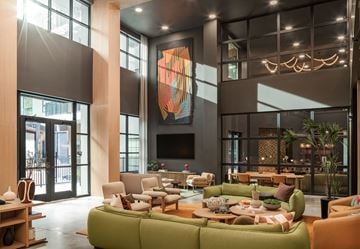 Austin apartment for rent - A modern living room with a green sofa and a large abstract painting on the wall.