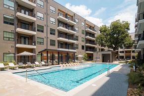 Austin apartment for rent - A large swimming pool is surrounded by apartment buildings.