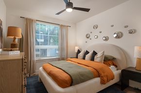 Austin apartment for rent - A bedroom with a bed, nightstand, and a ceiling fan.