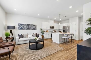 Denver townhouse for rent - A modern living room with a white couch and a black coffee table.