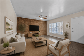 Austin apartment for rent - A living room with a couch, chair, and a television.