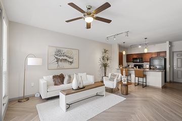 Pearland apartment for rent - A living room with a white couch and a ceiling fan.