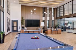 Scottsdale apartment for rent - A pool table is in the middle of a room with a couch and a TV.
