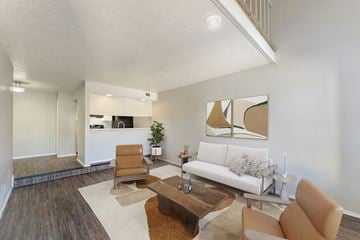 Lubbock apartment for rent - A living room with a white couch and brown chairs.