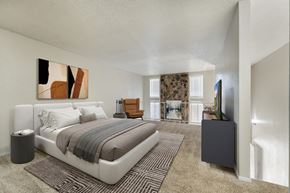 Lubbock apartment for rent - A bedroom with a large bed and a painting on the wall.