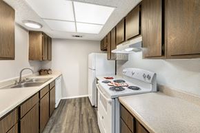 Lubbock apartment for rent - A kitchen with a white stove top oven and a white refrigerator.
