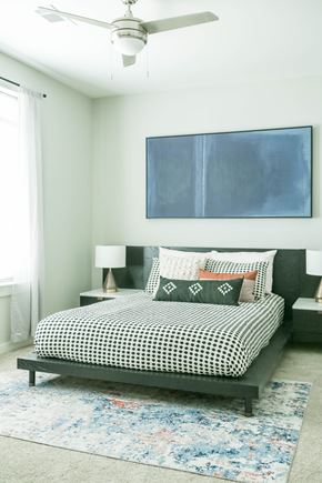 Nashville apartment for rent - A bedroom with a bed, a ceiling fan, and a painting on the wall.