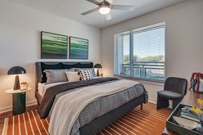 Houston apartment for rent - A bedroom with a large bed and a ceiling fan.