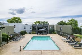 Albuquerque apartment for rent - A swimming pool surrounded by lounge chairs and umbrellas.