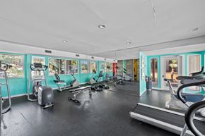 Austin apartment for rent - a gym with treadmills and other exercise equipment and windows