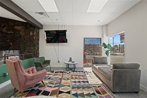 Mesa apartment for rent - A living room with a stone wall and a flat screen TV mounted on the wall.