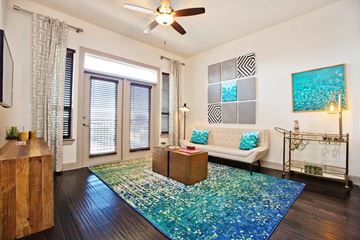 Houston apartment for rent - A living room with a white couch and a blue rug.