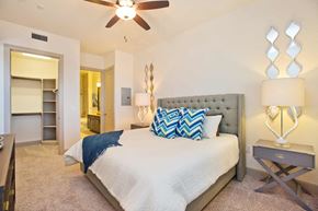 Houston apartment for rent - A bedroom with a bed, a nightstand, and a ceiling fan.