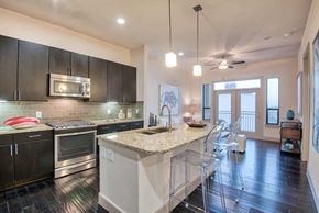 Houston apartment for rent - A modern kitchen with dark wood cabinets and stainless steel appliances.