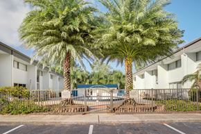 Jacksonville apartment for rent - a building with palm trees and a pool in front of it