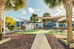 Jacksonville apartment for rent - a courtyard with grass and hammocks and a building in the background