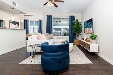 Henderson apartment for rent - A living room with a white couch and a blue chair.