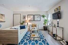 Atlanta apartment for rent - A bedroom with a bed, a chair, and a TV mounted on the wall.