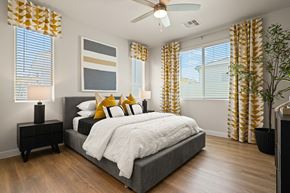 Tolleson apartment for rent - a bedroom with a bed and windows with yellow curtains