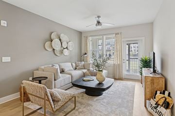Pooler apartment for rent - A living room with a sofa, chair, and a table with a vase on it.