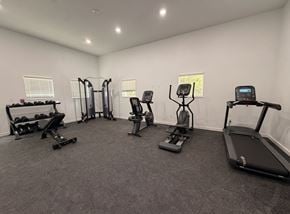 Moore apartment for rent - A spacious room with a variety of exercise equipment including treadmills, elliptical machines, and weights.