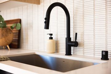 Los Angeles apartment for rent - A modern kitchen sink with a black faucet and a white countertop.