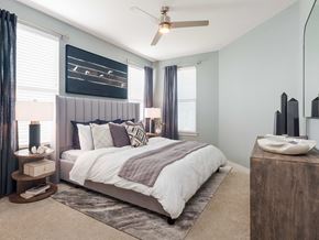 Cibolo apartment for rent - A bedroom with a large bed and a ceiling fan.