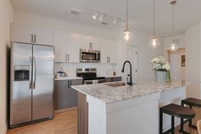 Leander apartment for rent - A modern kitchen with a stainless steel refrigerator and a marble countertop.