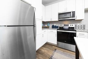 Stockbridge apartment for rent - a kitchen with stainless steel appliances and white cabinets