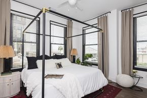 Savannah apartment for rent - A bedroom with a four poster bed and a red rug.