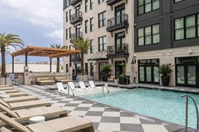 Savannah apartment for rent - A pool with sun loungers and a building in the background.