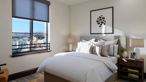 Long Beach apartment for rent - A bedroom with a large bed and a view of the city through the window.