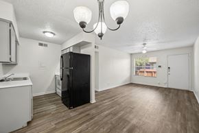 Stephenville apartment for rent - A kitchen with a black fridge and wooden floors.