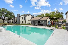 Dallas apartment for rent - A swimming pool in a sunny day surrounded by buildings.