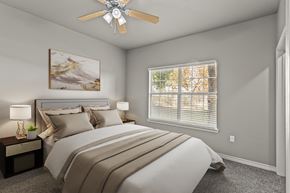 Waco apartment for rent - A bedroom with a large bed and a ceiling fan.