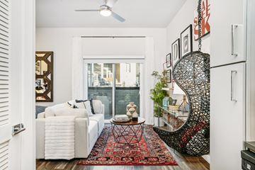 Denver apartment for rent - A living room with a white couch and a red rug.