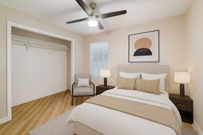 Fort Worth apartment for rent - A bedroom with a bed, two lamps, a chair, and a painting on the wall.