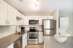 Fort Worth apartment for rent - A modern kitchen with stainless steel appliances and white cabinets.