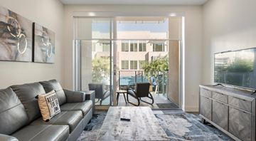 Phoenix apartment for rent - A living room with a grey couch and a chair.