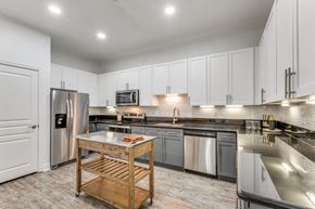 Baton Rouge apartment for rent - a large kitchen with stainless steel appliances and white cabinets
