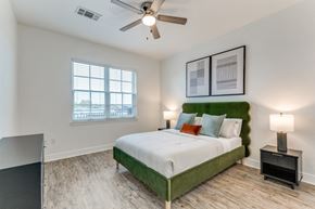 Baton Rouge apartment for rent - a bedroom with a green and white bed and a ceiling fan