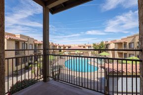 Yuma apartment for rent - A view from a balcony overlooking a pool and apartment buildings.