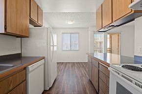 Yuma apartment for rent - A kitchen with wooden cabinets and white appliances.
