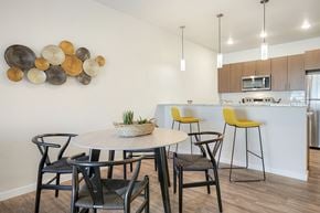 Aurora apartment for rent - A modern dining room with a round table and chairs.