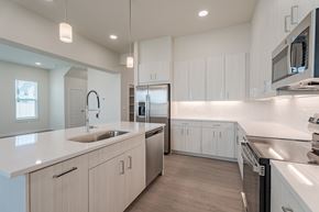 Richmond apartment for rent - A modern kitchen with white cabinets and stainless steel appliances.