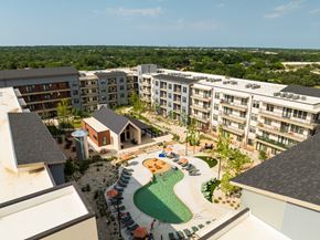 Austin apartment for rent - A view of a resort with a pool and a green lawn.