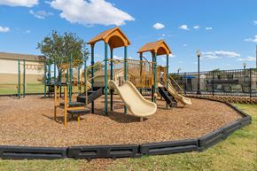 Amarillo apartment for rent - A playground with a yellow slide and two orange towers.