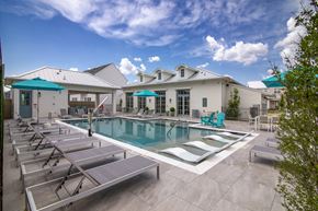 Richmond apartment for rent - A pool with sun loungers and a building in the background.