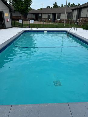 Oklahoma City apartment for rent - A small empty pool with a blue tiled edge.